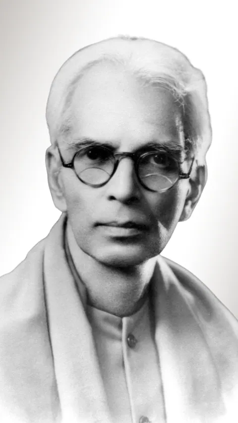 Retrato em preto e branco de N. Sri Ram, de óculos redondos e cabelos brancos, vestindo um xale claro.