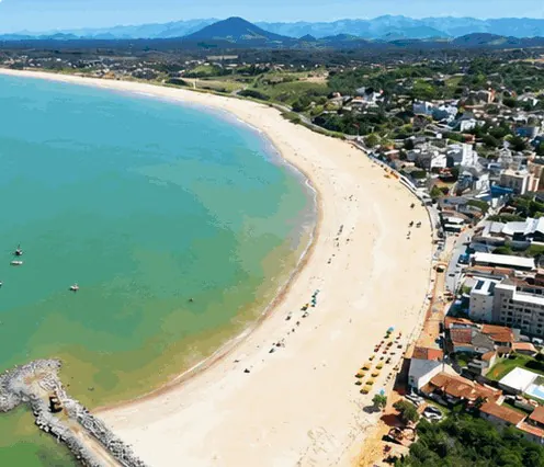 Vista aérea da praia de Meaípe: areia clara em curva, mar verde e um morro pontudo ao fundo